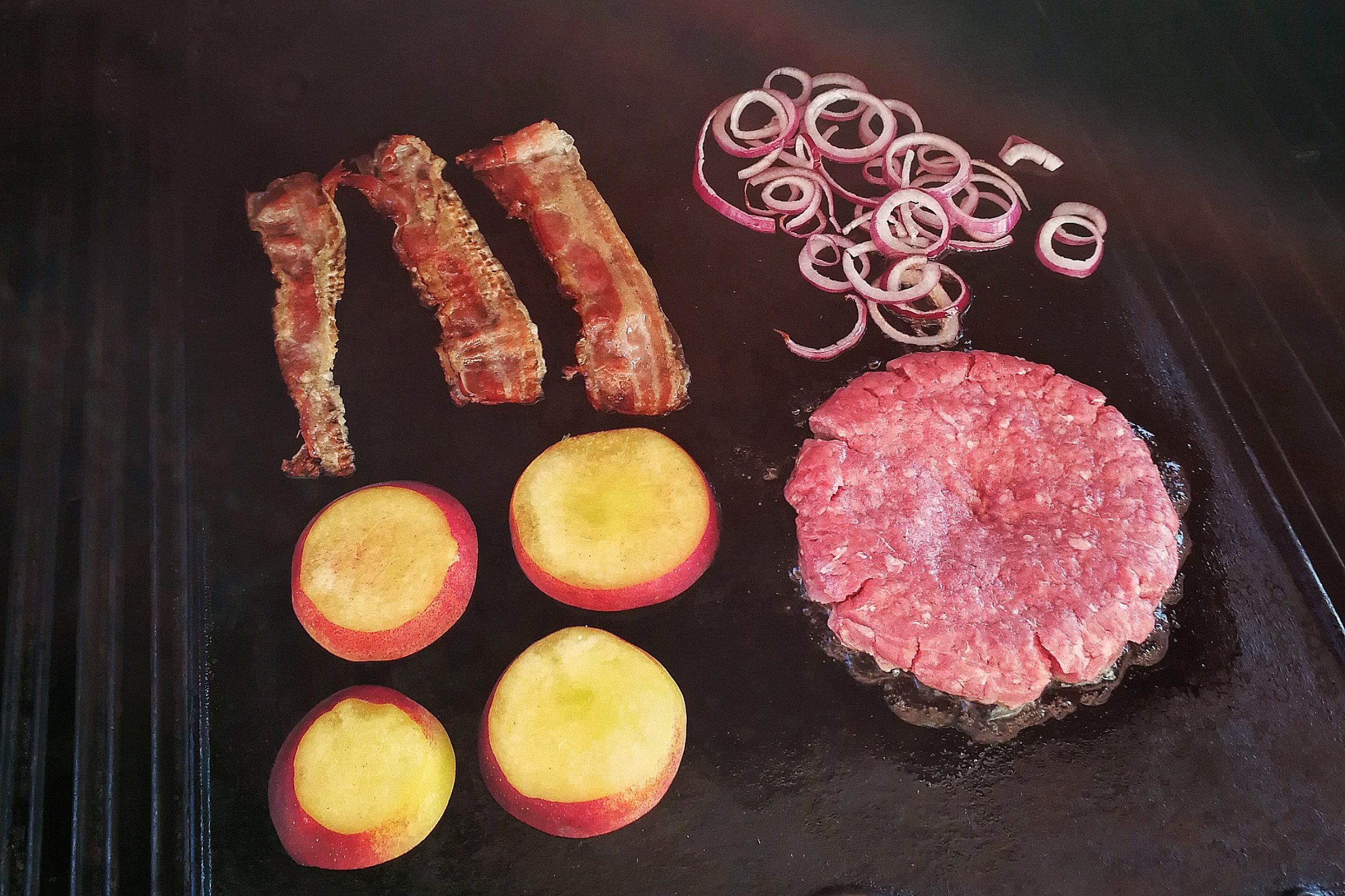 Pfirsich, Ziebeln, Bacon und Fleisch auf dem Grill