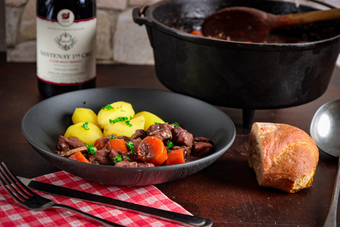 Tellerbild: Bœuf Bourguignon – ein Fleischgericht aus Frankreich Gedeckter Tisch mit Dutch Oven mit Boeuf Bourguignon