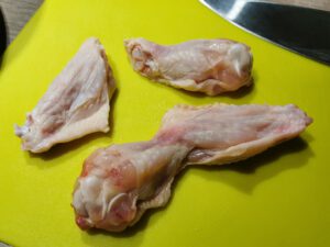 Chicken Wings im Gelenk auseinander schneiden